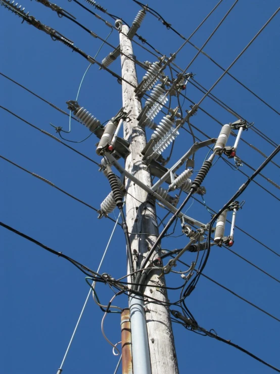 a close up of an electrical pole with wires and pylons