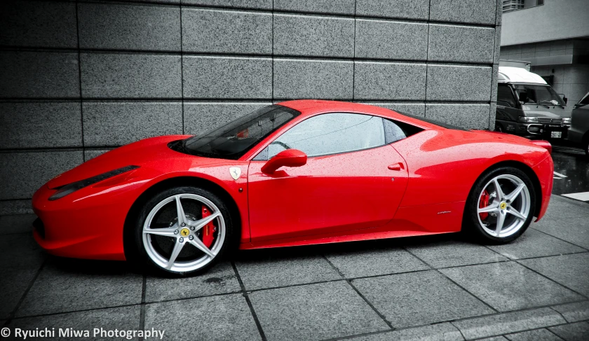 a red sports car parked on the street in front of a building