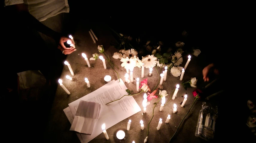 a group of lit candles are lined up on the ground