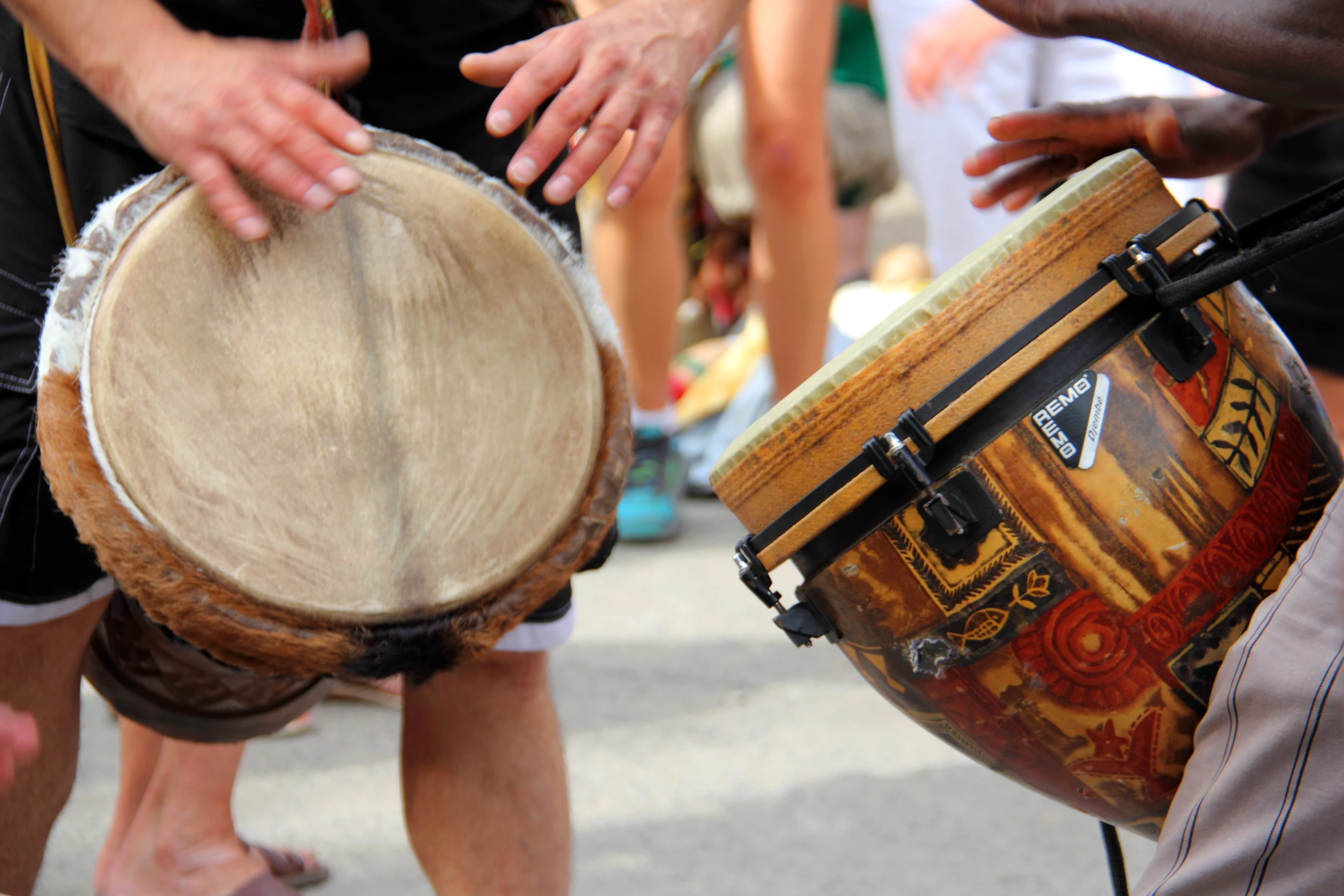 two men are playing a djembe with drums