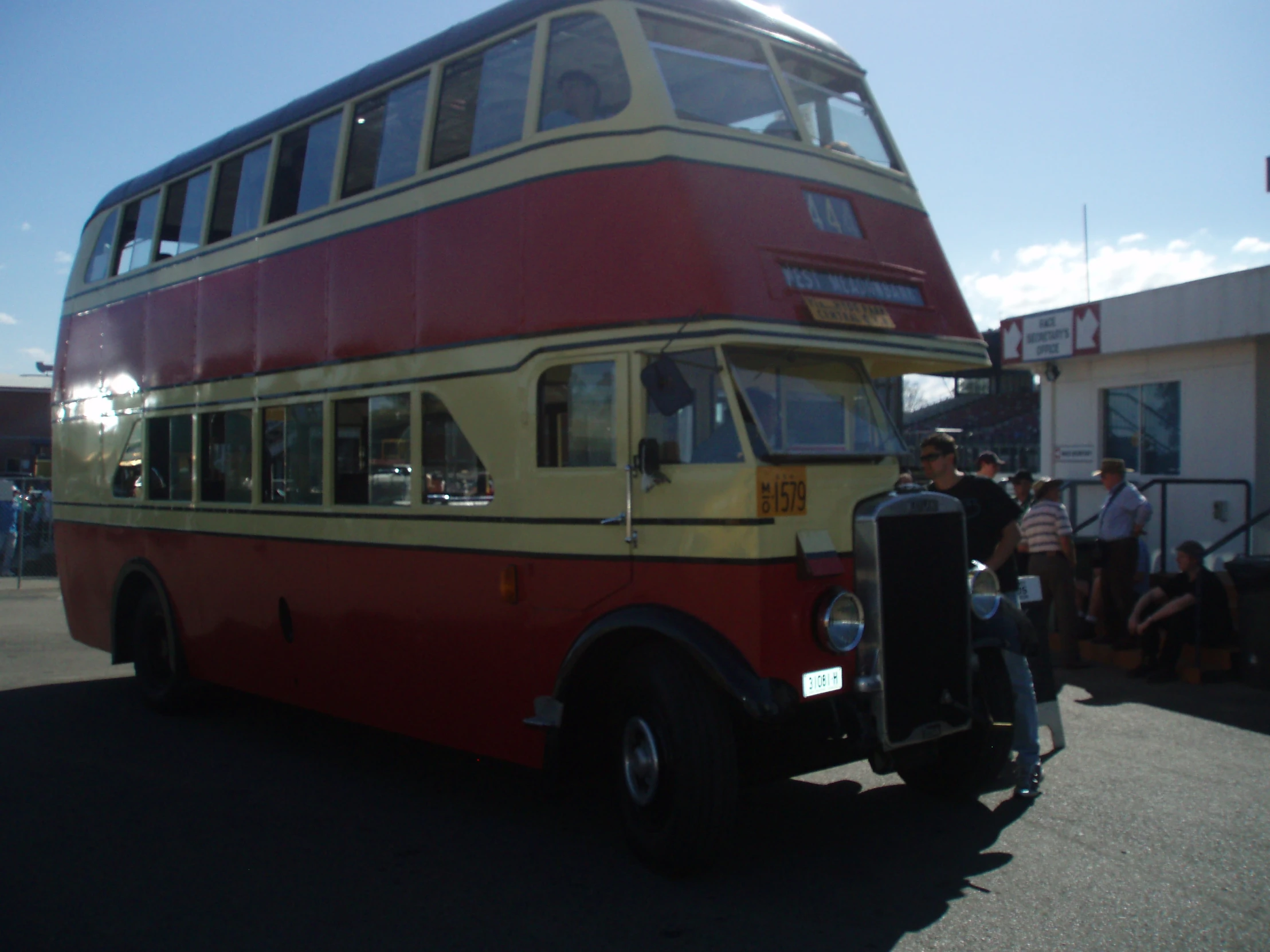 people gathered around a double decker bus at a festival