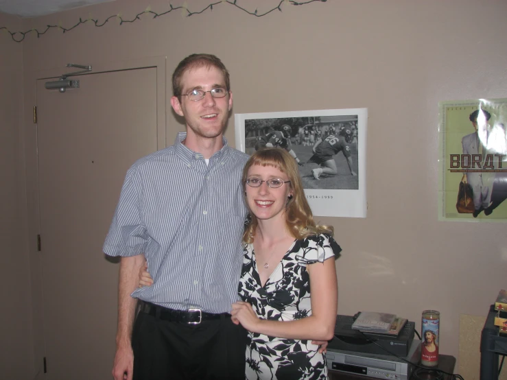 two people standing next to each other in a room