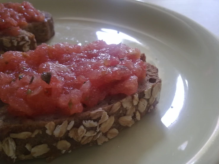 a white plate topped with two slices of toast covered in tomato sauce