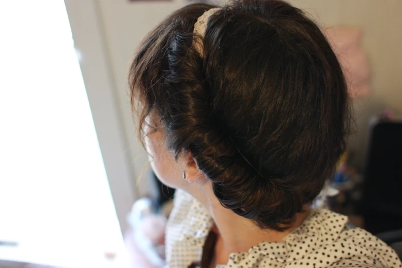 the back view of a woman with a bun in her hair