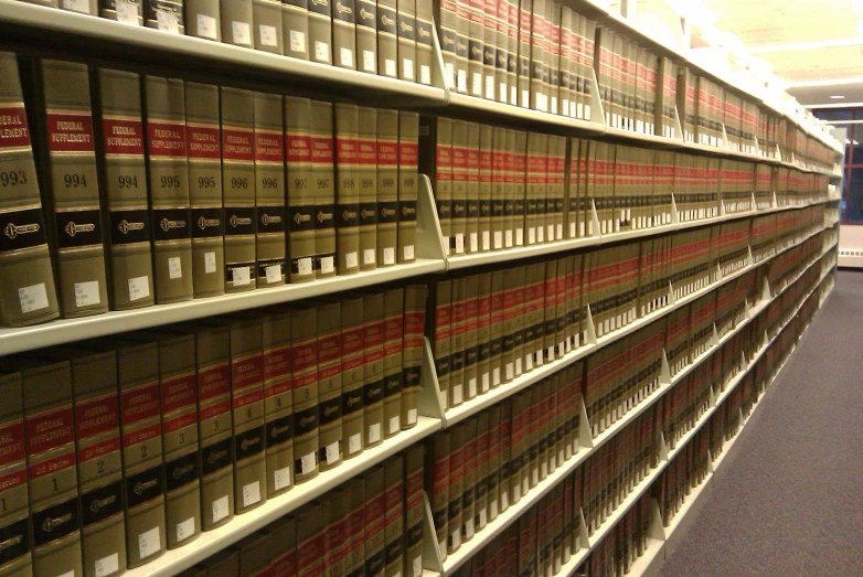 a wall full of binders of books with a door open