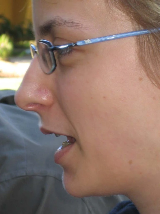 a woman with glasses and nose ring talking on the phone