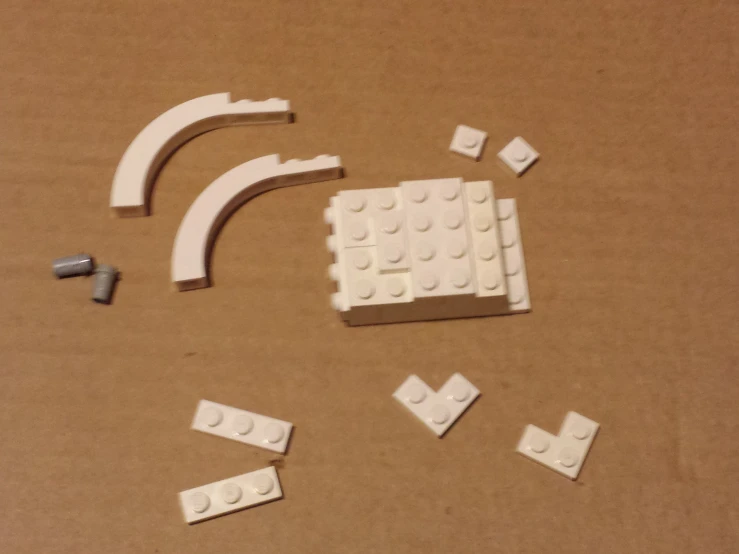 some white legos and white brick parts laying next to each other