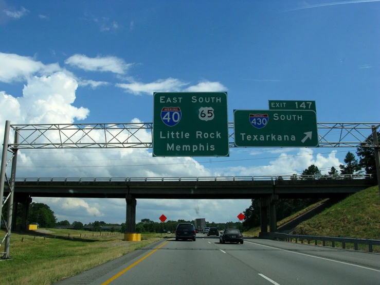 a large highway sign next to a highway