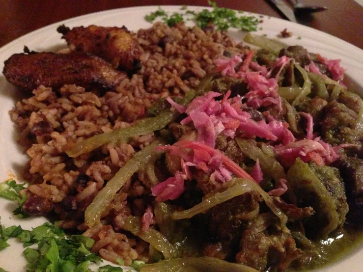 a plate of food with rice, meat and vegetables on it