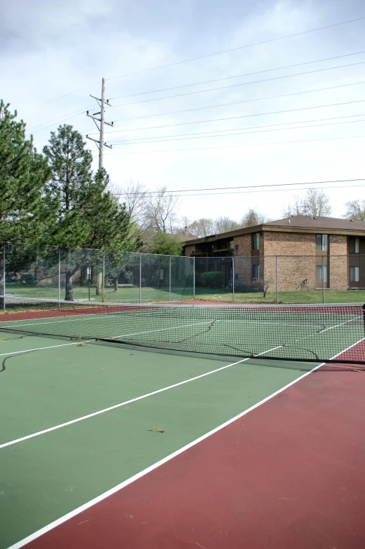two people playing tennis on an outdoor tennis court