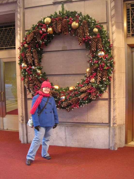 a woman that is standing by some wreaths