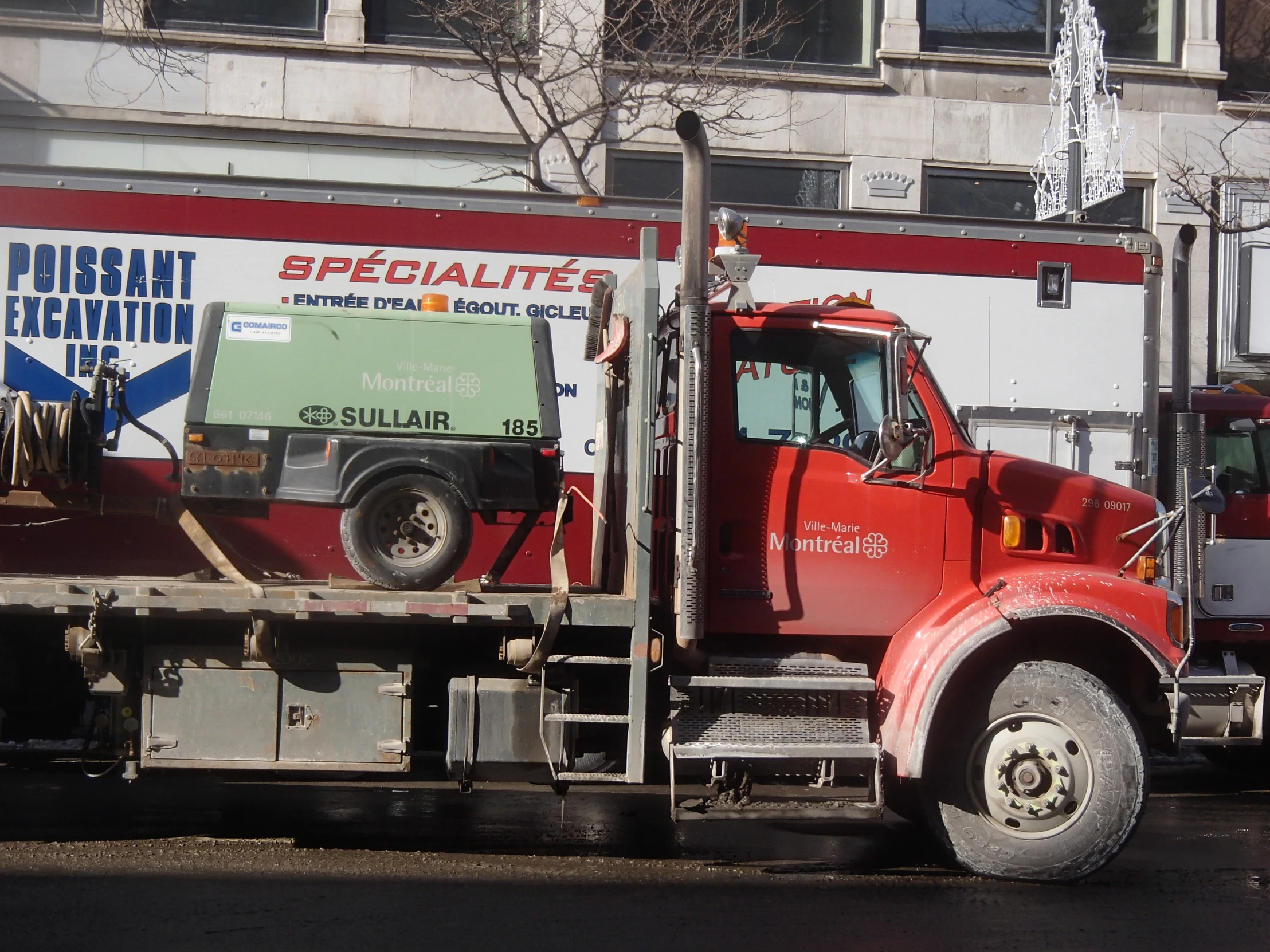 a red tow truck driving down the street