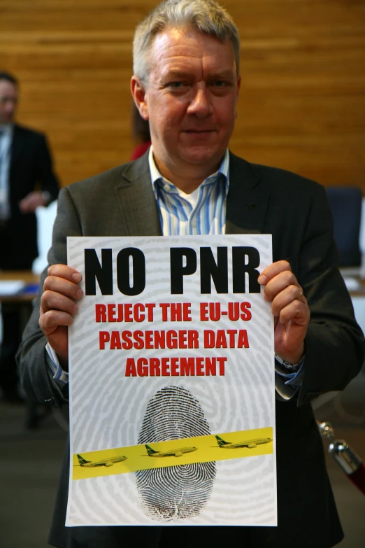 a man holding up a sign stating no pnnr