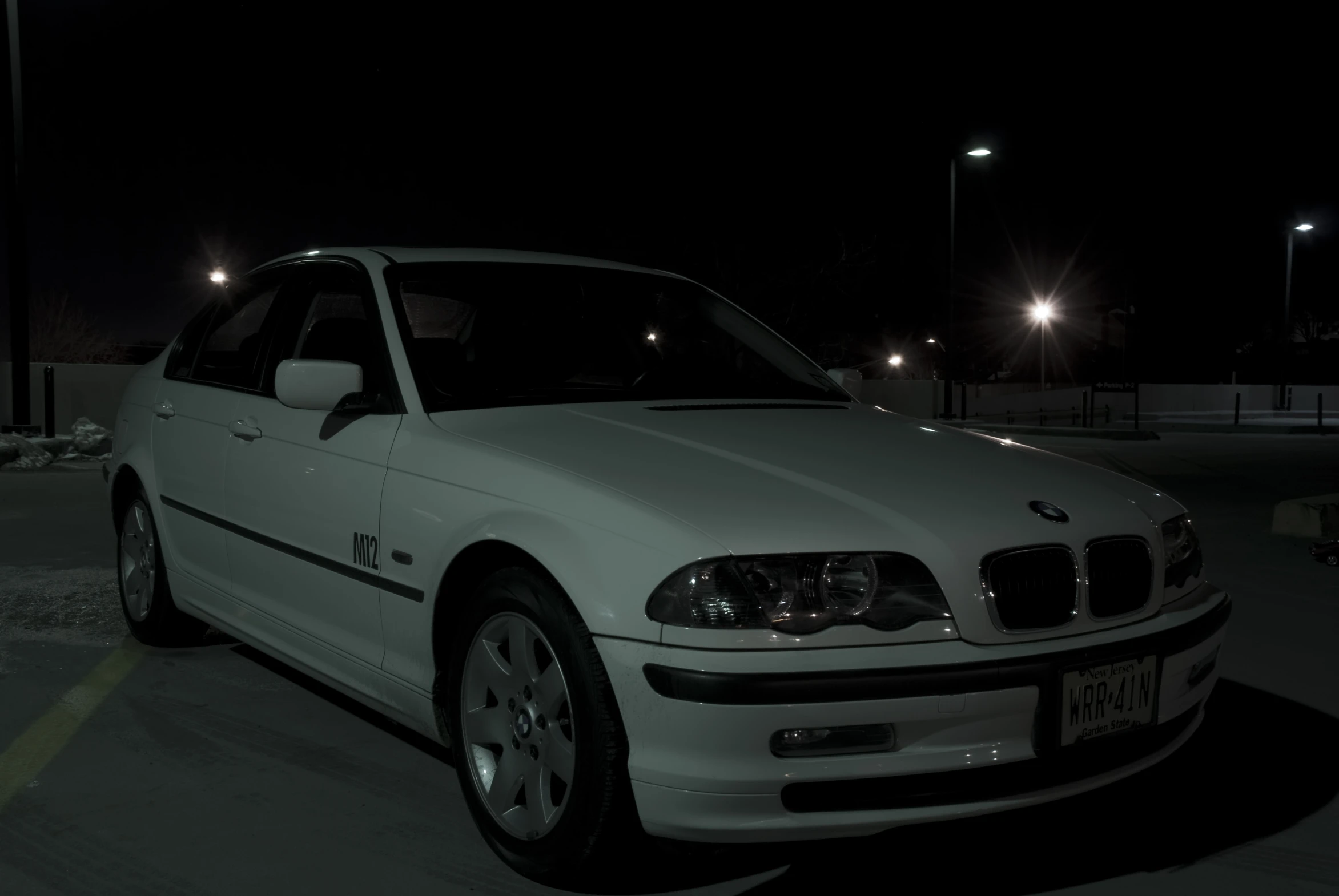 a white car is parked at the side of the road