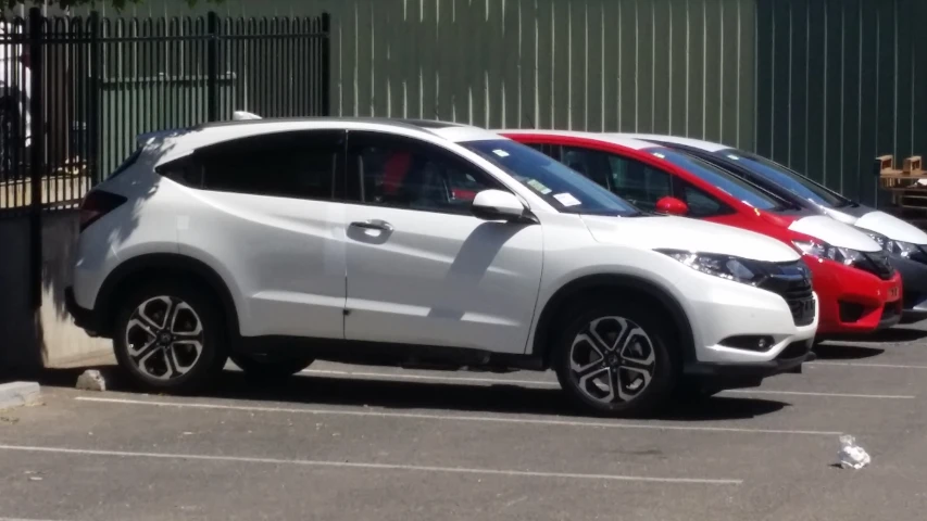 several cars in a parking lot with fence