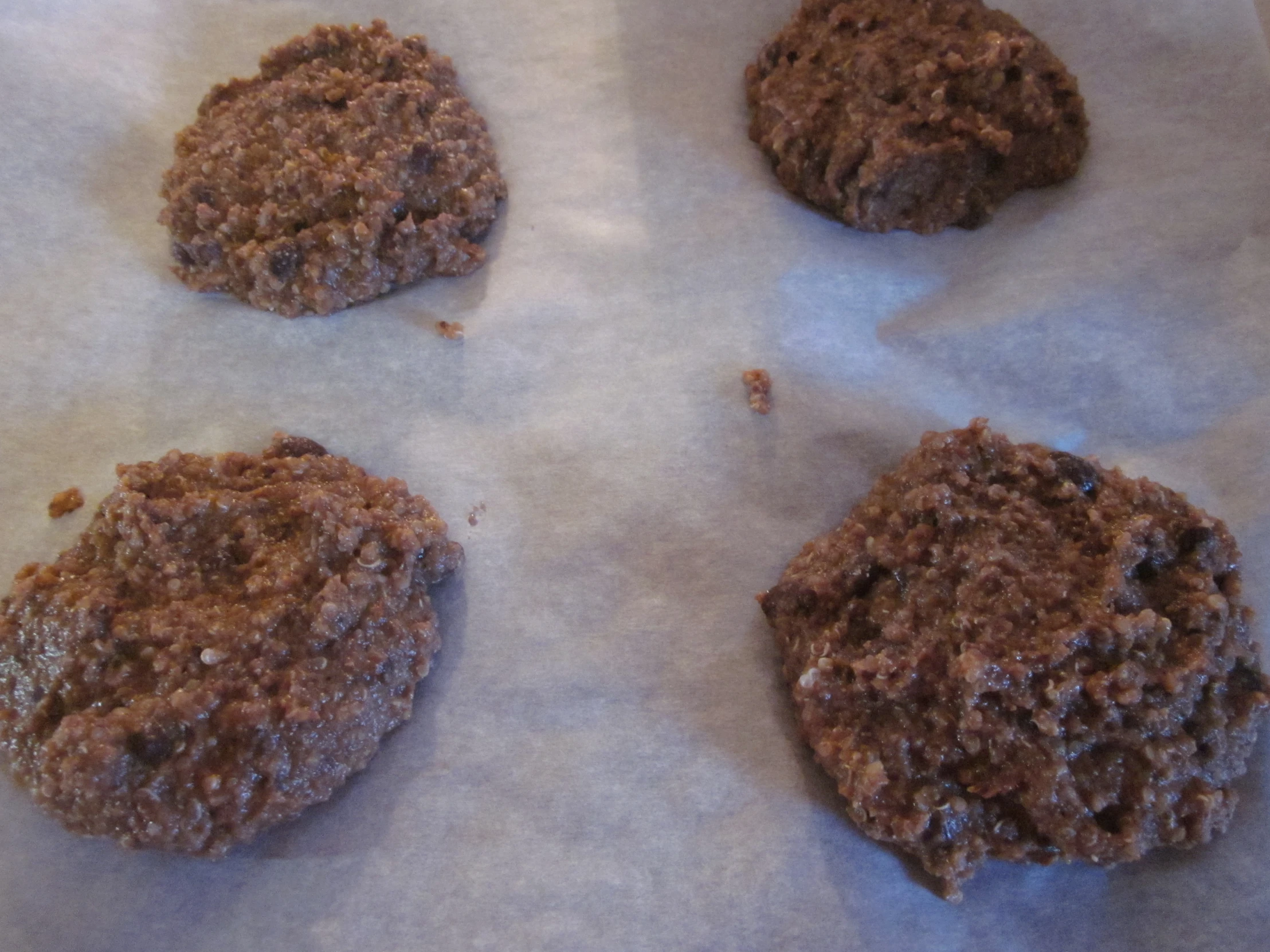 three cookies sitting on a table with paper