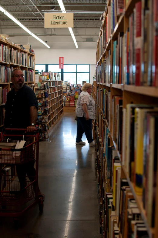 a store filled with lots of books and people walking