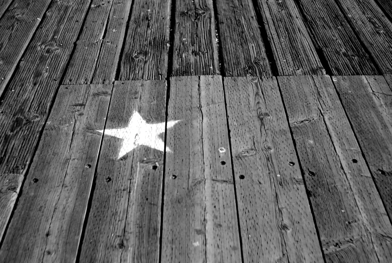 a lone white star in the middle of a wooden floor