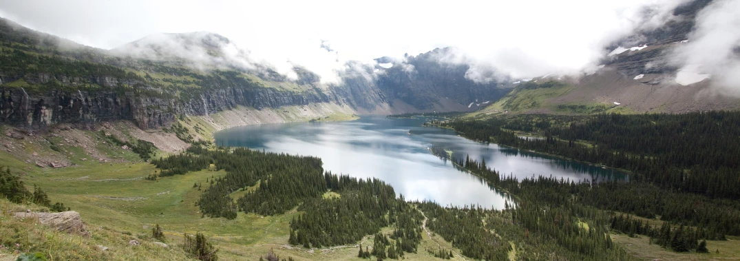 a view of a lake in a valley with tall mountains