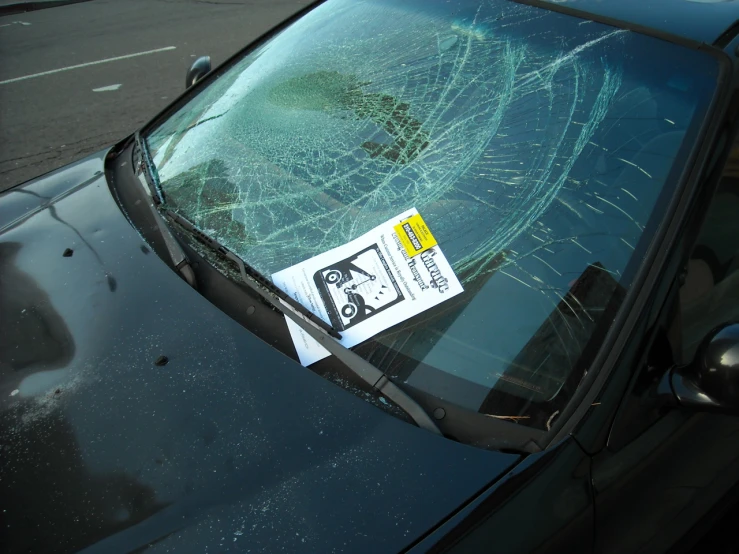 a windshield is shattered and there is a yellow sticker on it