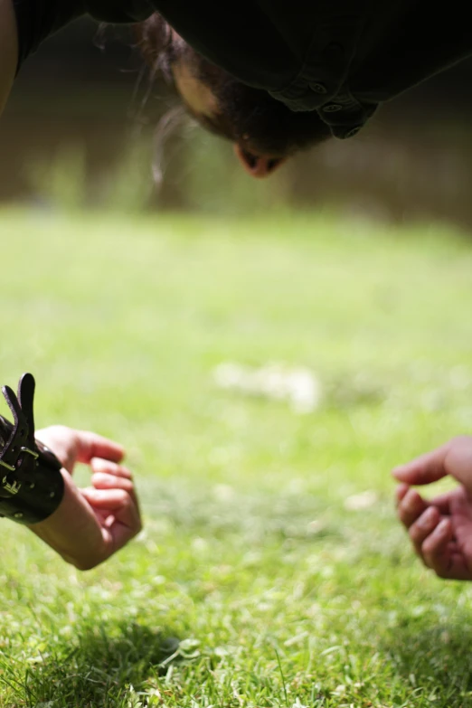 a person reaching up to pick a glove off the ground