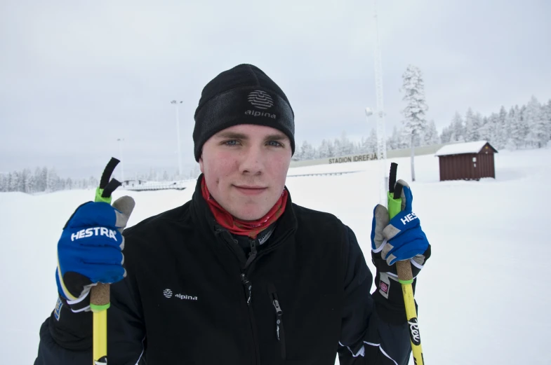 a skier standing in the snow holding ski poles