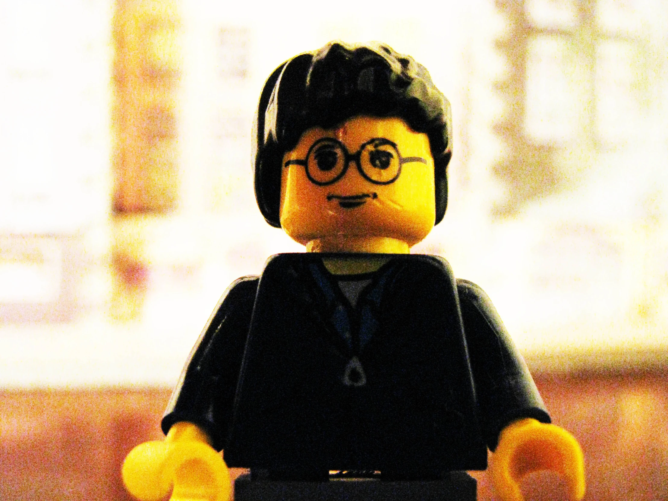 lego figure with black wig and glasses wearing headphones