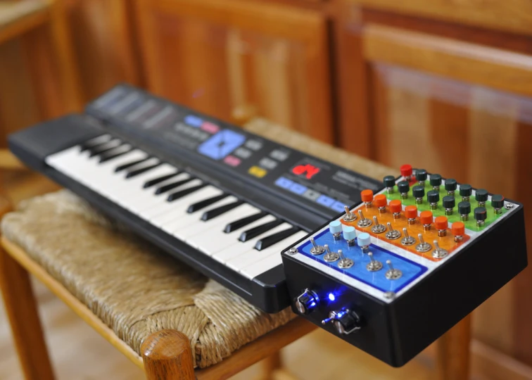 a multi colored midi controller sitting on top of a wooden chair