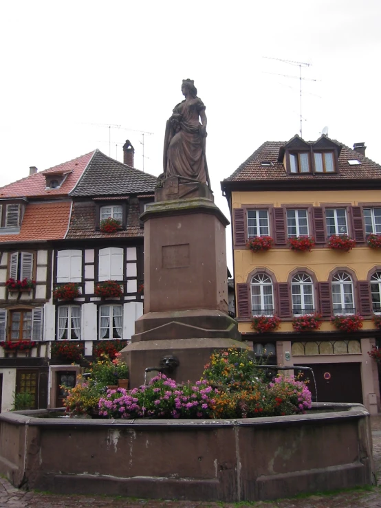 a statue sits in front of buildings in a european city