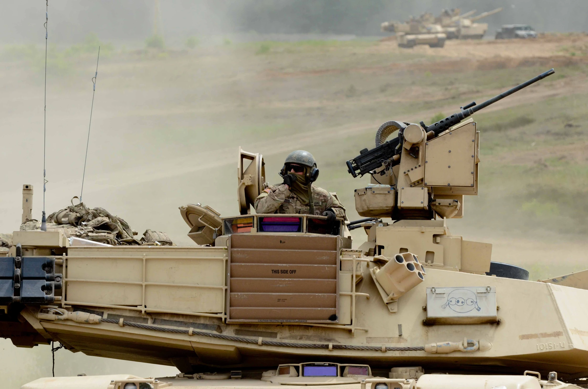 a soldier riding in a armored vehicle