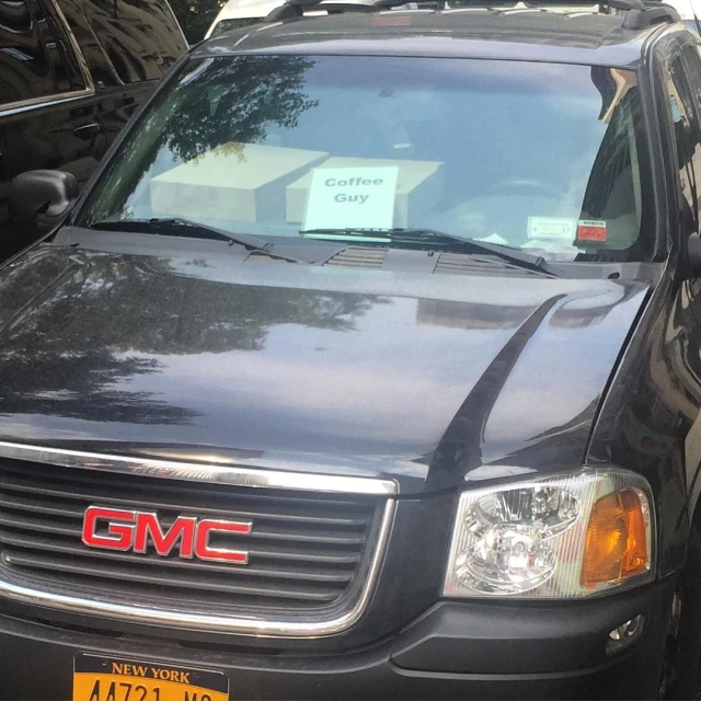 a black gmc wagon parked in front of a store