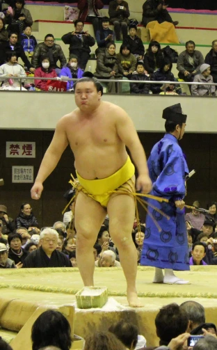 a sumo wrestler is holding his rope at an event