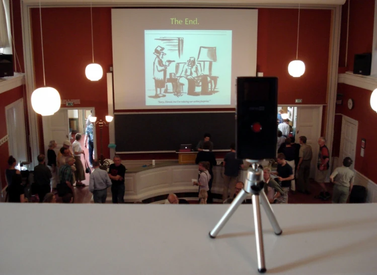 a camera taking a po of people in a room with red walls