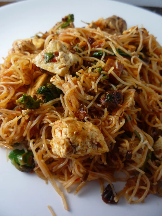 a plate topped with spaghetti and meat covered in sauce