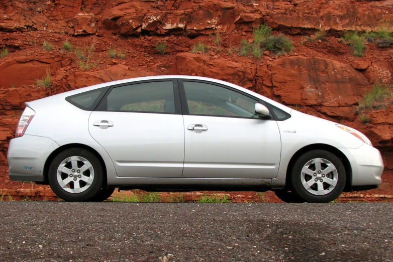 a car is parked in front of a rock wall