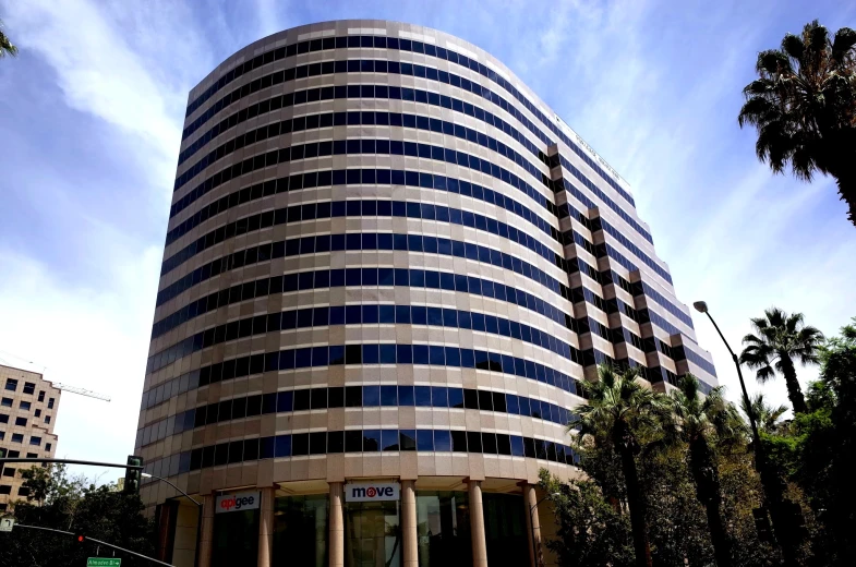 the building has blue windows and a curved balcony