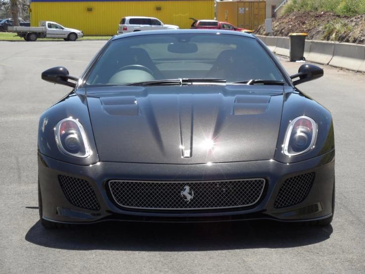 a grey sports car with headlights on in parking lot