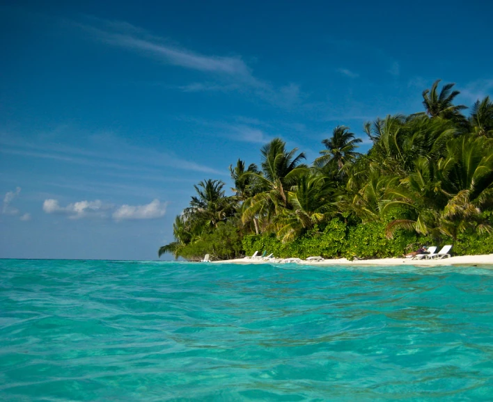 two people laying out on the sand next to the water