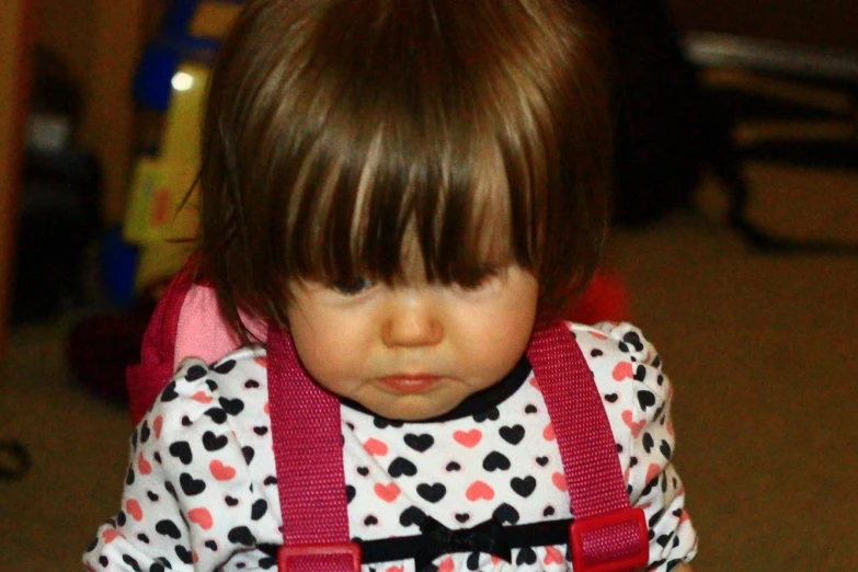 small toddler girl in dress on floor with cell phone