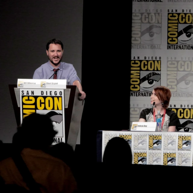 a man at a panel speaking into a microphone