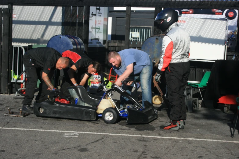 a group of men working on soing in a race car