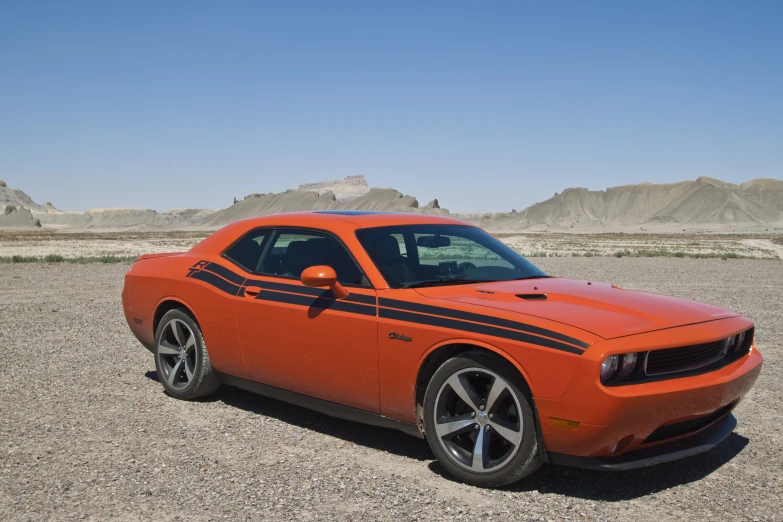 the orange car is parked in an empty lot