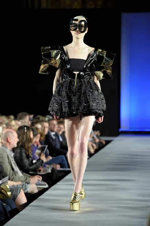 a woman walking down a runway during a fashion show