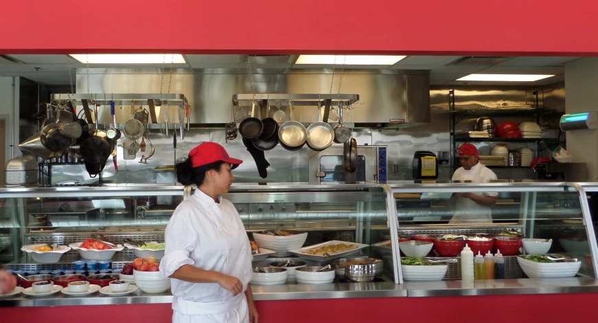 two women in chefs coats cooking behind glass