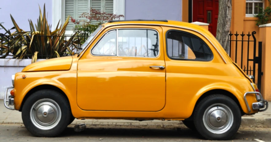 the old car is parked on the side of the road