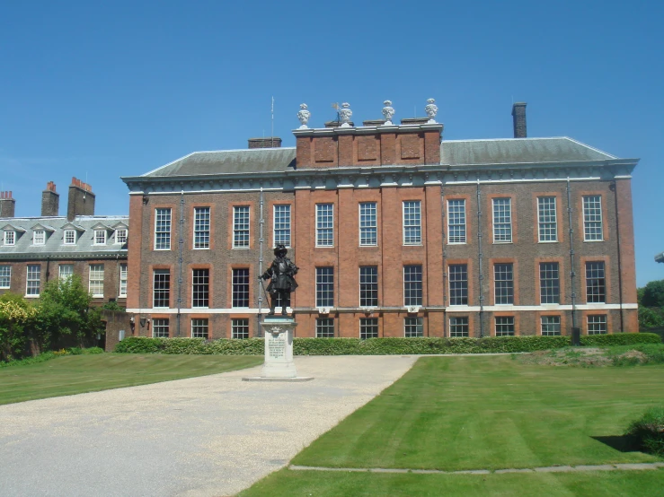 a tall brick building with large front yard