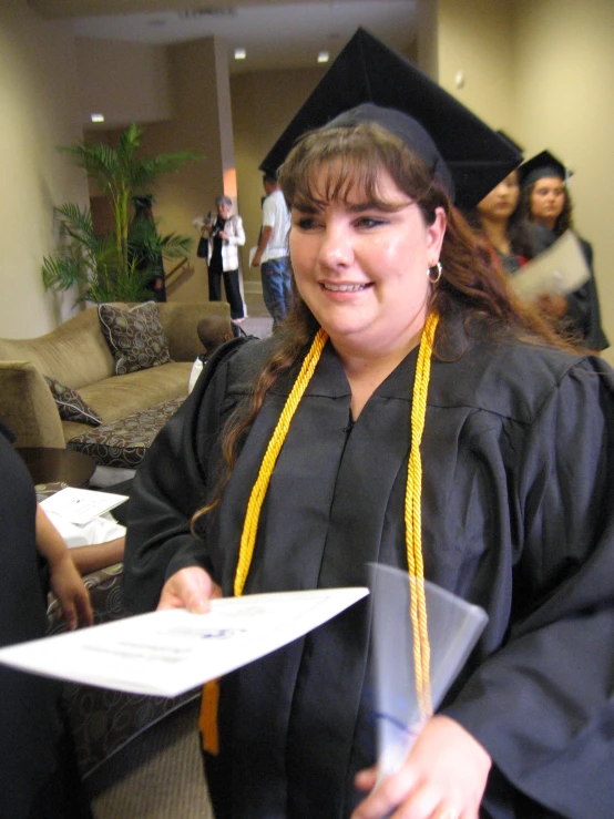 a woman smiling and holding a piece of paper