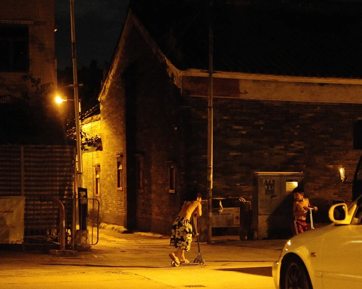 a dark city with people walking and a car at night