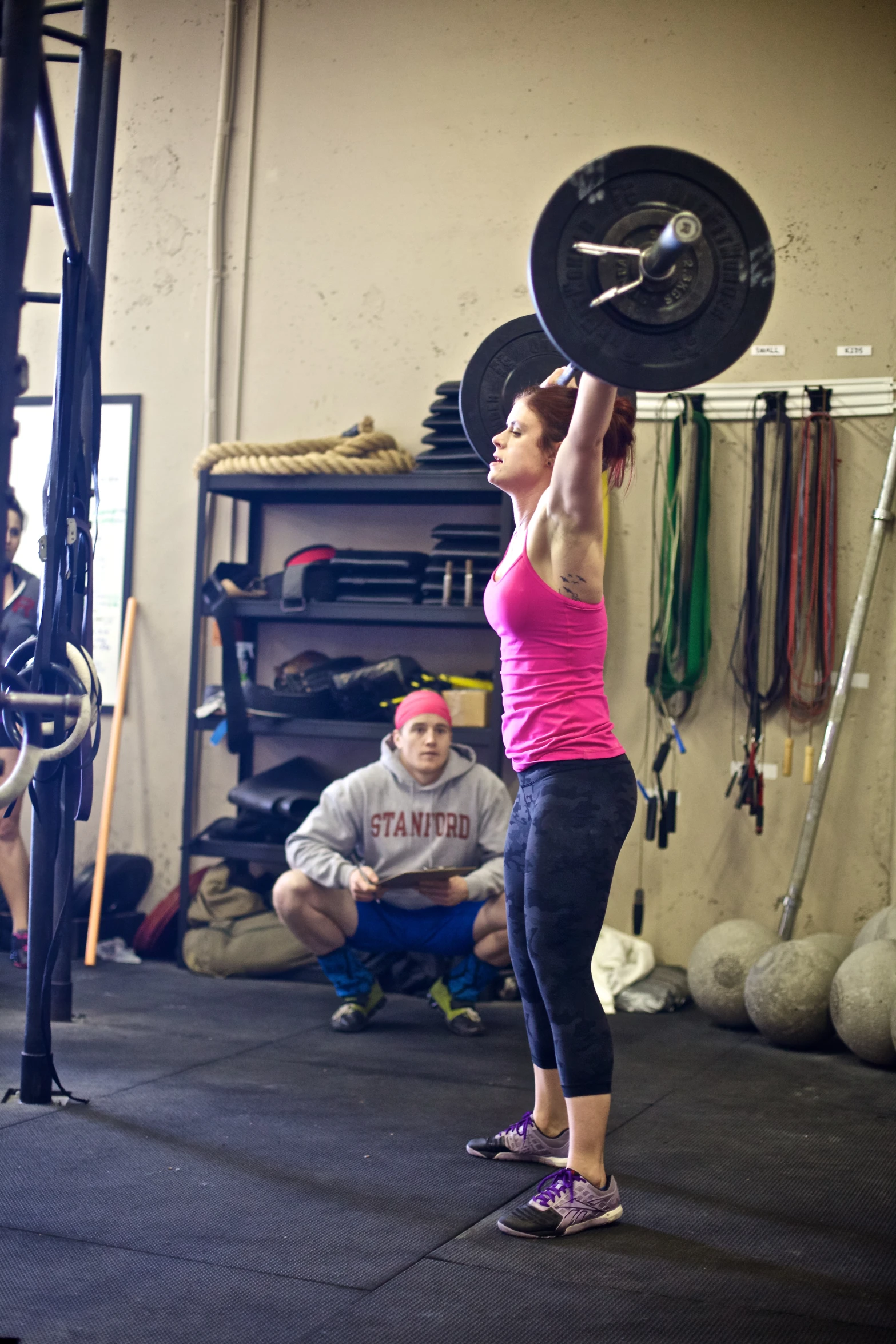 a woman lifting a barbell at a crossfit competition