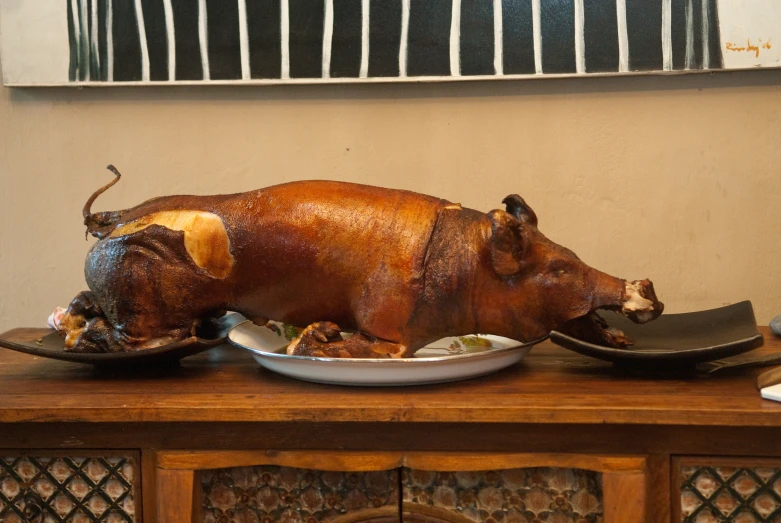 a fake pig is sitting on a plate on a buffet